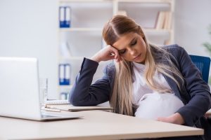 A pregnant woman in a workplace experiencing discrimination.