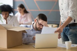 Frustrated upset male employee receiving unfair dismissal notice